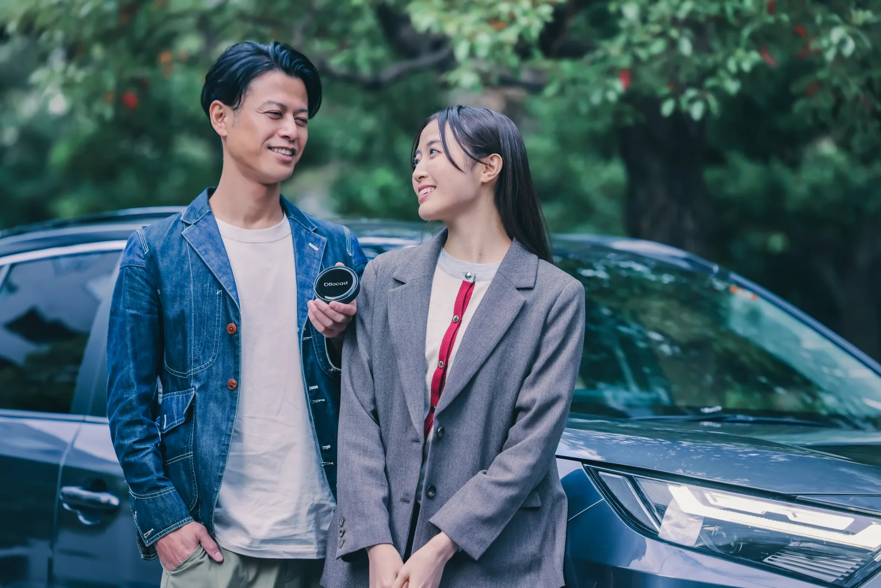 車のそばでOttocast製品を確認しているサポートイメージ